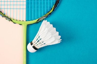 Mekik siki ve badminton raketini mavi arkaplanda kapat.