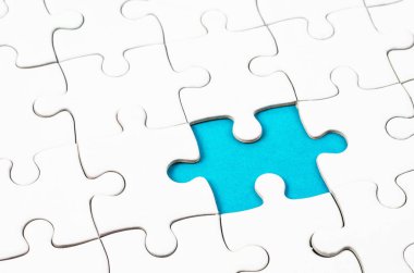 Arka plan mavi plastik yüzey katlanmış bir beyaz jigsaw bulmaca parçası. 