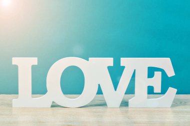 Mavi zemin üzerine beyaz ahşap kelime aşk.