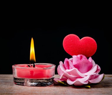 Kırmızı mum, kırmızı kalp ve pembe gül. Valentine konsepti.
