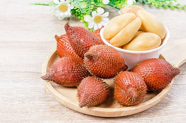 Salak Palm , waive or snake fruit in wooden dish on the table.
