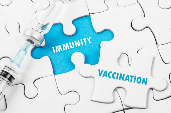 Vacunación y texto de inmunidad con vial de vacuna en puzzle . — Foto de Stock