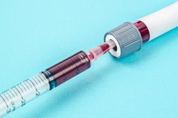Échantillon de sang en seringue et tube sanguin . — Photo