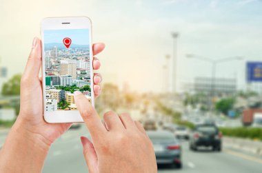 navigasyon haritasının bir kısmını gösteren bir akıllı telefon tutan kadın elleri