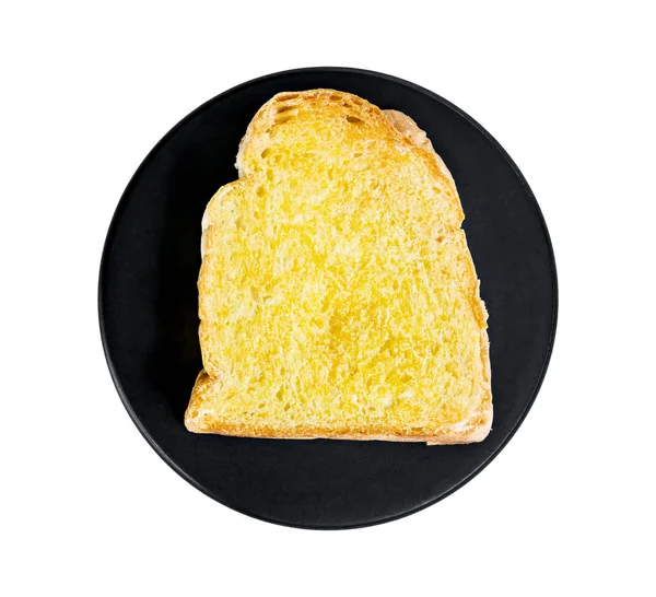 Toastbrotscheiben auf schwarzem Teller. — Stockfoto