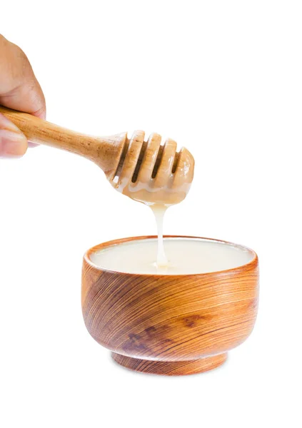 Pouring condensed milk into wooden bowl. — Stock Photo, Image