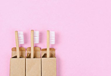 Pembe arka planda bambu diş fırçaları.
