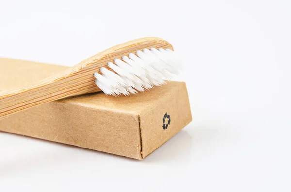 Bamboo toothbrushes on brown paper box with recycle sign. — Stock Photo, Image