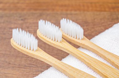 Tahta zemin üzerinde havlu olan bambu diş fırçaları.. 
