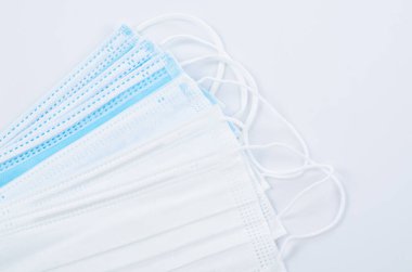 Tıbbi maske ya da plastik kulaklıklı cerrahi maske. Ağız ve burnu örtmek için tipik 3 katlı cerrahi maske. Bakterilerin prosedür maskesi. Koruma kavramı.