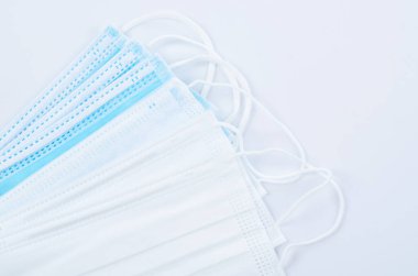 Tıbbi maske ya da plastik kulaklıklı cerrahi maske. Ağız ve burnu örtmek için tipik 3 katlı cerrahi maske. Bakterilerin prosedür maskesi. Koruma kavramı.