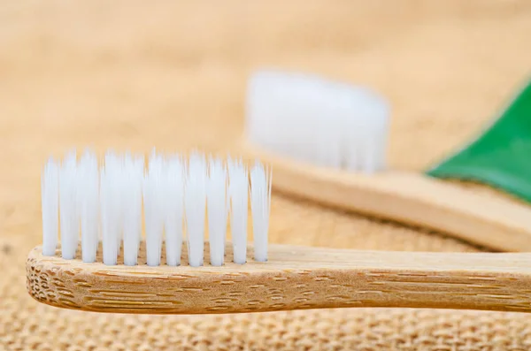 Närbild Bambu Tandborste Med Gröna Blad Säck Bakgrund Miljövänligt Koncept — Stockfoto