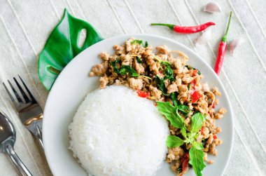 Kızarmış domuz pirzolası ve masa örtüsünde fesleğen..