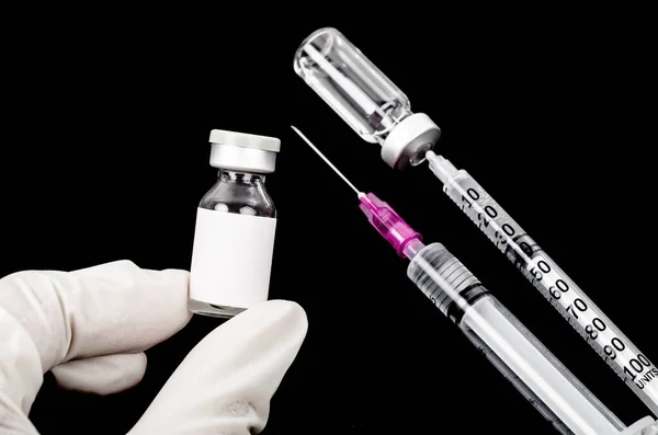 黒を背景にした予防接種と注射器 — ストック写真