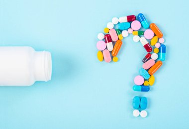 Mavi arka planda ilaç şişesi olan ilaçlardan kalma bir soru işareti..