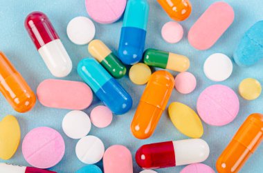 Mavi arka planda renkli haplar, haplar ve kapsüller