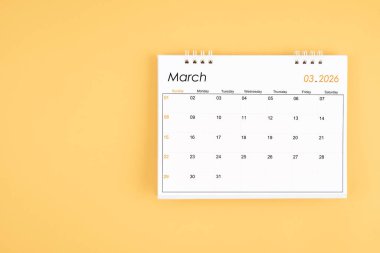 Sarı zemin üzerinde Mart 2026 masa takvimi, kopyalama alanı ile konum.