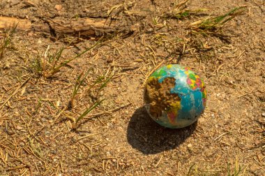 Küreyi ısırdı, karada dünyanın bir modeli.