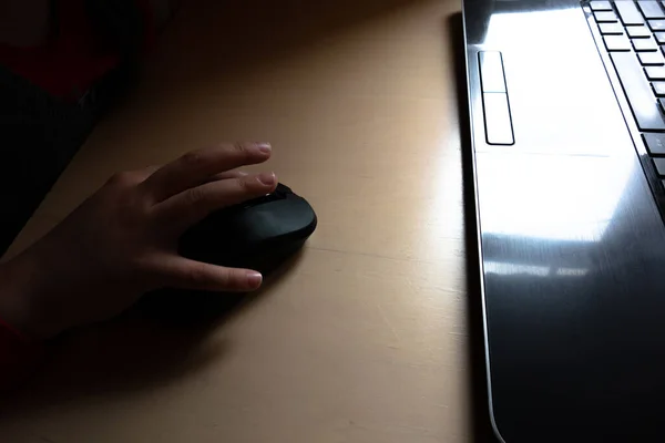 Child's hand with the mouse at the monitor screen
