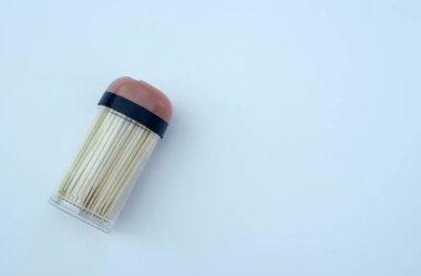 Beyaz izole edilmiş plastik bir kutuda tahta kürdanlar.
