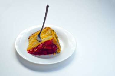 Üzerinde çilek olan beyaz cam bir tabak, tepesinde bir kaşık. Beyaz bir izolasyonda, yazıtlar için bir yer..