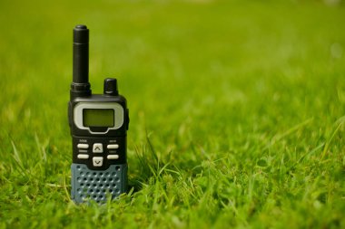 Telsiz yerde, yeşil çimenler bulanık, mesaj için yer var.