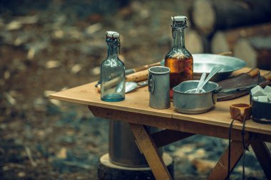 Vintage military tableware in a forest camp clipart