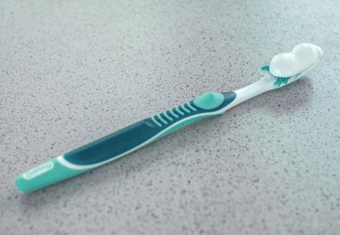 Fayans masasında beyaz macunla diş fırçası