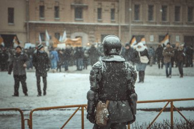 Kışın St. Petersburg 'da düzenlenen mitingde, bir polis memuru nizamı izler. 30.11.2009 Rusya