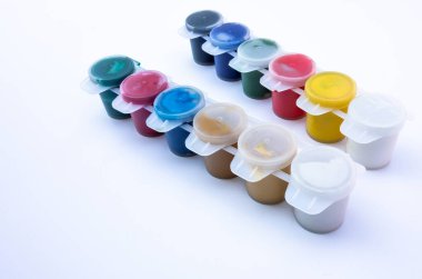 Beyaz izole edilmiş plastik kaplarda çok renkli akrilik boyalar.