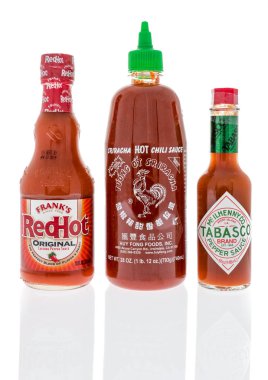Winneconne, Wi - 1 Temmuz 2018: en çok satan dünyada acı sos şişe içerir Frank'in redhot, Sriracha chili sos ve izole bir arka plan üzerinde Tabasco biber sosu.