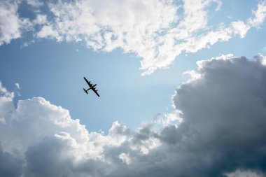 İkinci Dünya Savaşı uçan ek yükü bulutlar tarafından çevrili bir bombardıman uçağı
