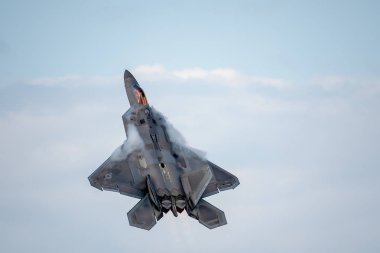 Oshkosh, Wi - 28 Temmuz 2018: contrails bir Havacılık Fuarında oluşturma afterburner ile uçan bir F-22.