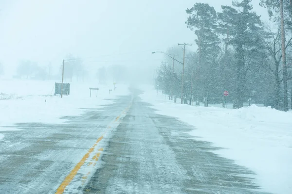 Bir ülkenin karayolu ile kar sürüklenir ve kar fırtınası sürerken.