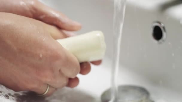 In Großaufnahme verdrehen die Hände ein Stück Seife. Handwäsche feste Seife. — Stockvideo