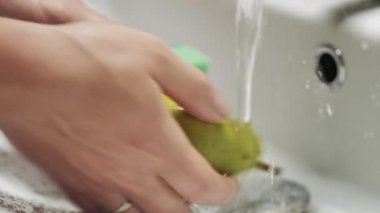 Armutları temiz suyun altında elle yıka. Yakın plan.