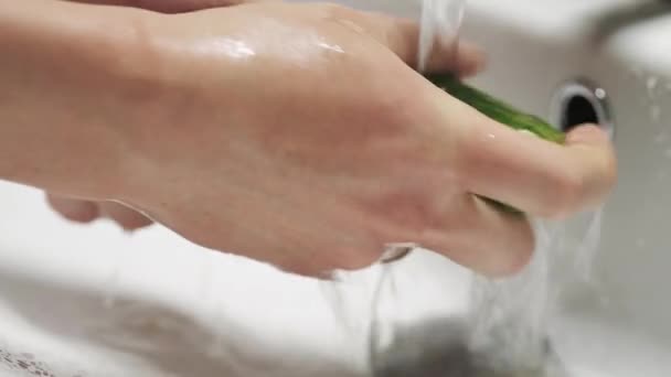 Πλύνετε στο χέρι το αγγούρι κάτω από τρεχούμενο νερό. Υγιεινή διατροφή. — Αρχείο Βίντεο