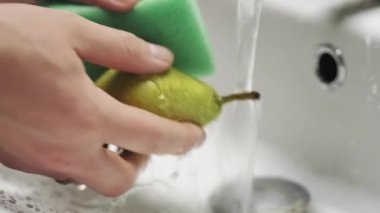 Armutları temiz suyun altında elle yıka. Yakın plan.