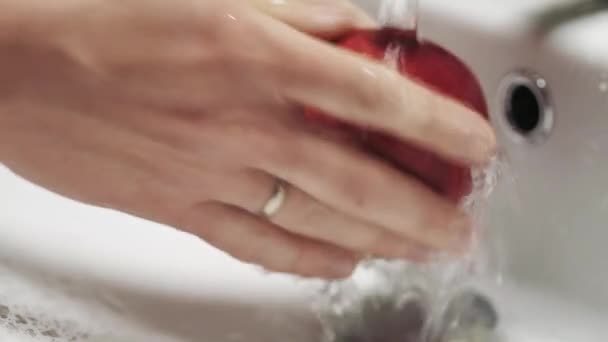 Gros plan des mains lavant une pomme rouge sous l'eau courante. Aliments sains et propres — Video