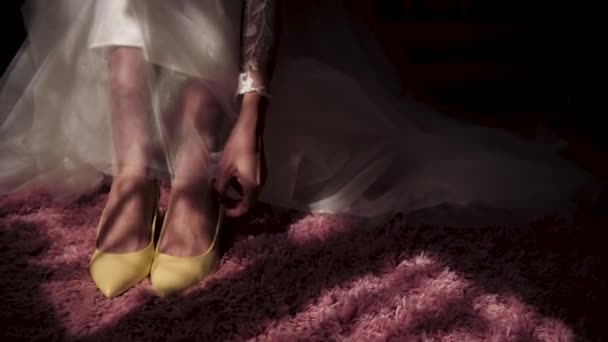 La novia lleva zapatos en una alfombra rosa. — Vídeo de stock