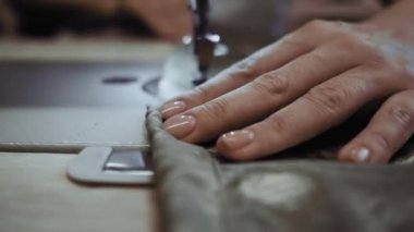 Dikiş makinesindeki terzi hafif kumaş diker..