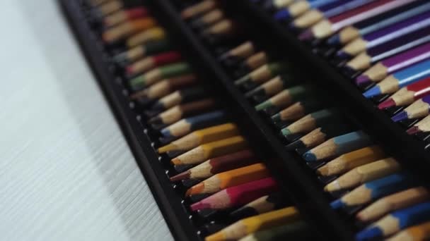 Pack noir / boîte de crayons de couleur couchés sur une table blanche — Video