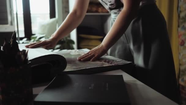 Красивые произведения искусства и рамка, как девушка рассматривает образцы красивой ткани — стоковое видео