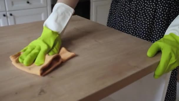 Νεαρή νοικοκυρά φορούν λαστιχένια προστατευτικά γάντια καθαρίζει ξύλινη επιφάνεια. Κοντινό πλάνο — Αρχείο Βίντεο
