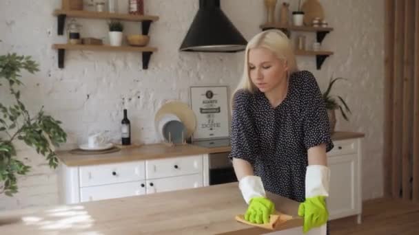 Η νοικοκυρά φοράει λαστιχένια προστατευτικά γάντια καθαρίζει την ξύλινη επιφάνεια και θυμώνει. 4K — Αρχείο Βίντεο