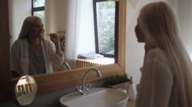 Banyoda dişlerini fırçalayan bir kız. Ağız temizliği..