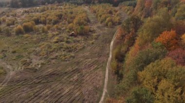 Kamera bir kır yolunun üzerinde uçuyor.