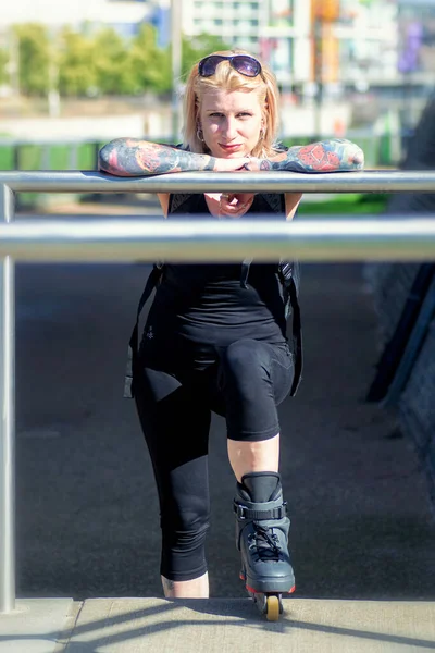 Mulher loira com tatuagens e patins posando — Fotografia de Stock