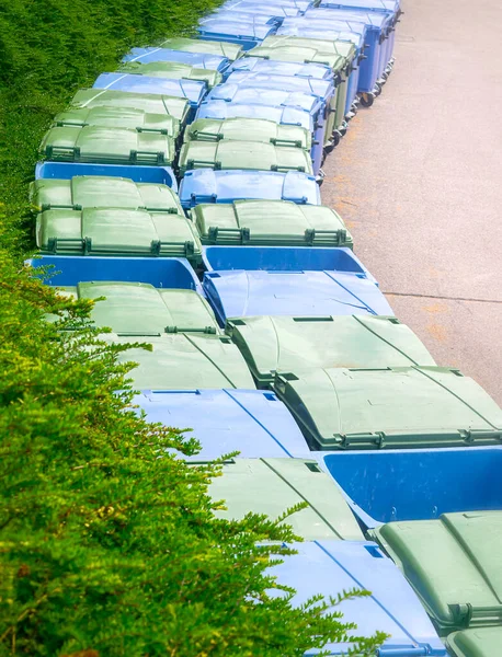 Green and blue recycling bins in a row