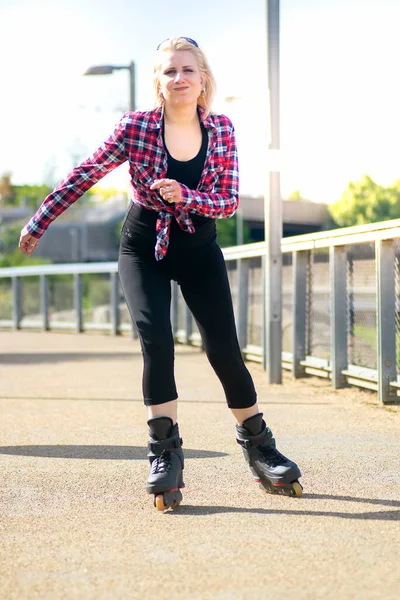ブロンド女性ローラースケートオンザ舗装屋外 — ストック写真